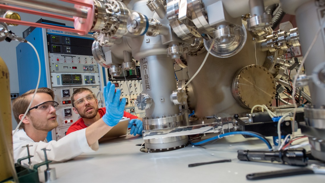 Researchers fiddling with complex machinery 