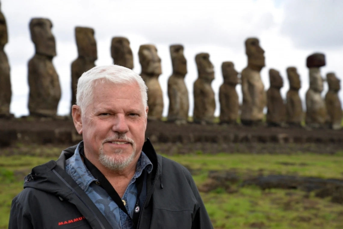 Honors Dean Terry Hunt on Easter Island with moai statues in background.