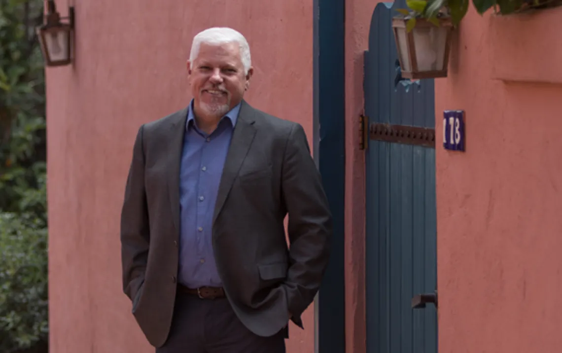 Honors Dean Terry Hunt - Standing outside by pink wall and green door