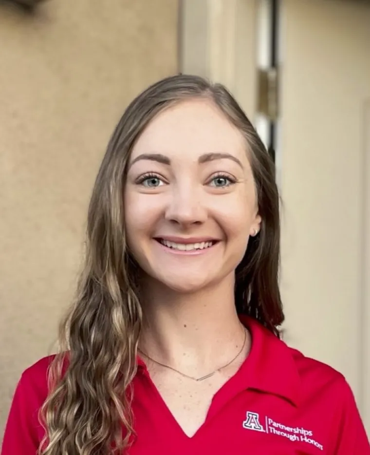 headshot of woman wearing red shirt that reads partnerships through honors