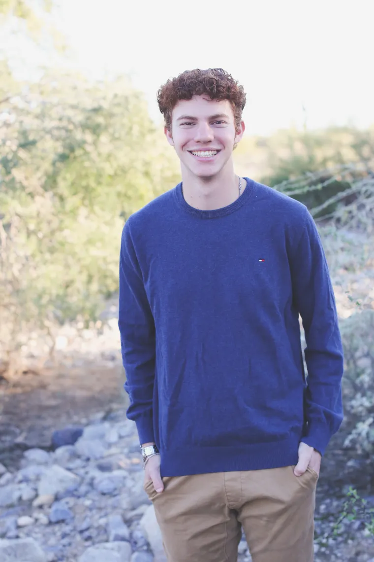 student wearing blue shirt with green background