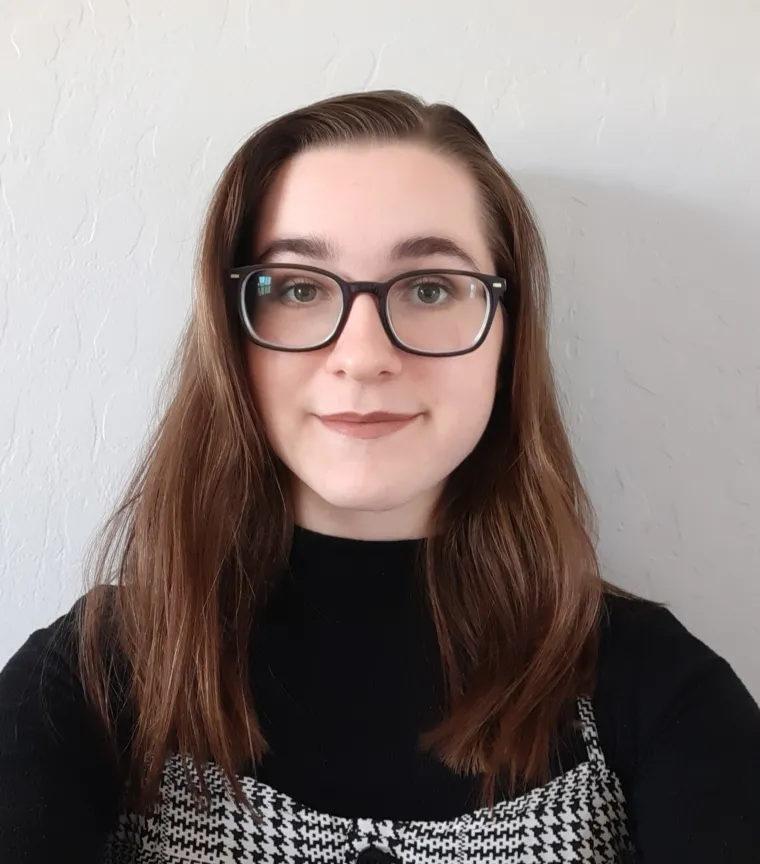 close up headshot of student wearing black with glasses