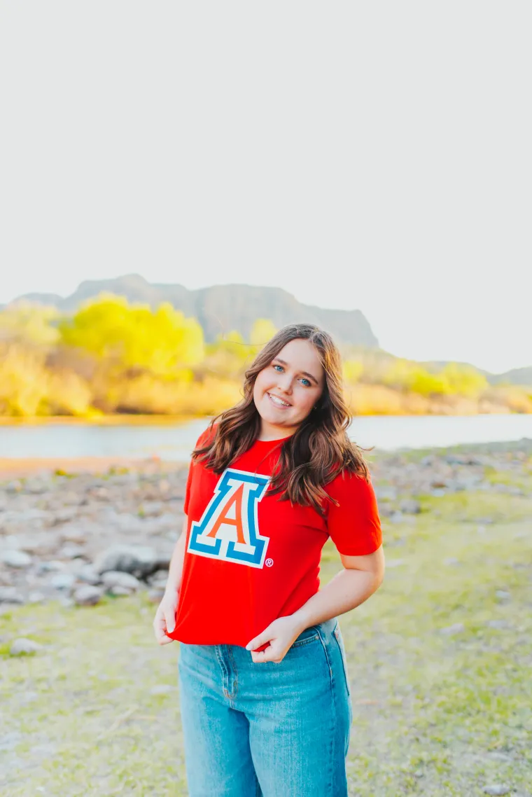 student wearing a red shirt with a landscape background