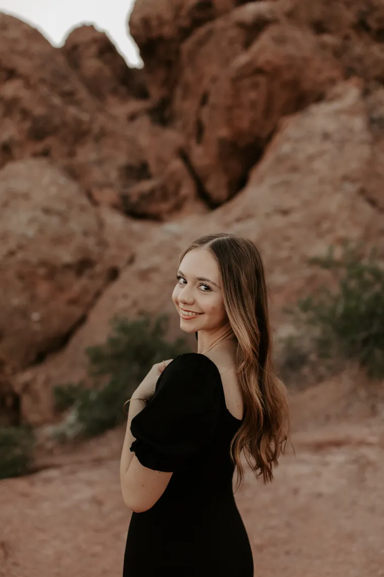 woman wearing black standing in front of red rocks