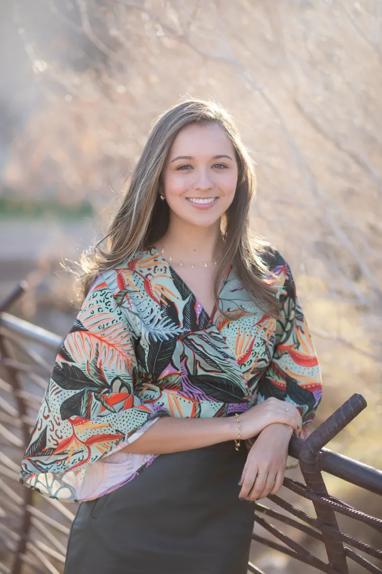 woman leaning on fence wearing colorful dress