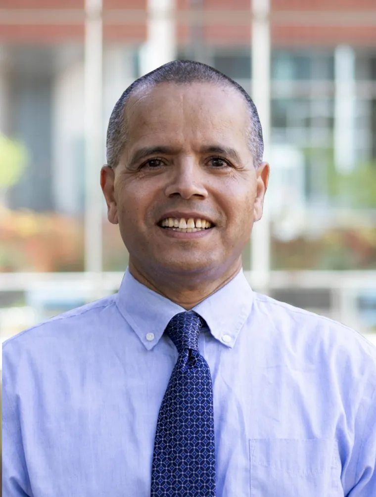 Headshot of Hsain in a blue tie and light blue shirt 