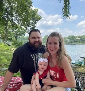 family sitting by water green background