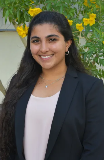 student headshot green background yellow flowers