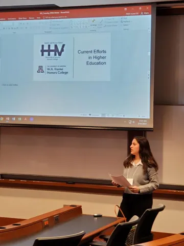 Woman presenting with powerpoint background reading HHV