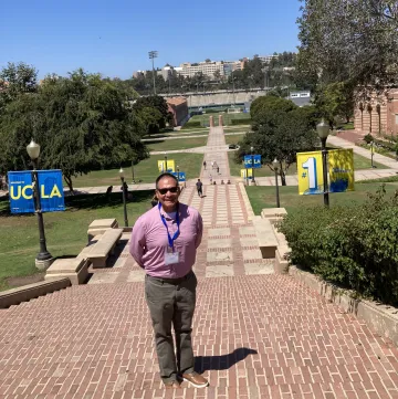 student standing in front of steps smiling 