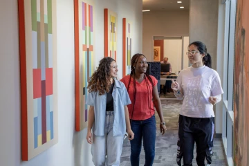 Three students walk through the Honors offices.