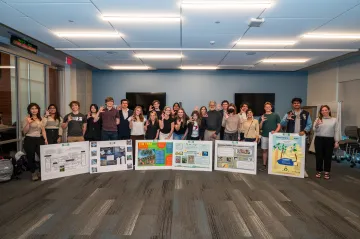 students with posters showing wildcat hand symbol