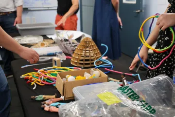 table with craft materials such as bendy straws and wood pieces