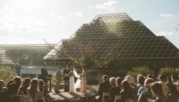 wedding scene in front of glass building