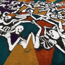 art installation with skeleton figures and colorful rocks