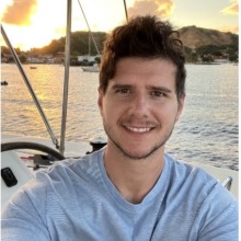 man on a boat in front of sunset with water in background