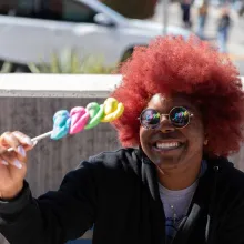 Student sitting outside eating colorful candy.