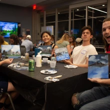 Students holding their paintings they made