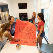 Two students making bear down sign