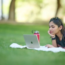 Student studying on grass lawn