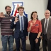 four people showing wildcat hand symbol pictured in front of University of Arizona Block A