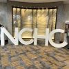 two people standing with big letters that read NCHC