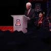 Bill Franke standing in front of graduates delivering speech