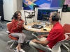 two people sitting in front of podcast equipment