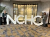 two people standing with big letters that read NCHC